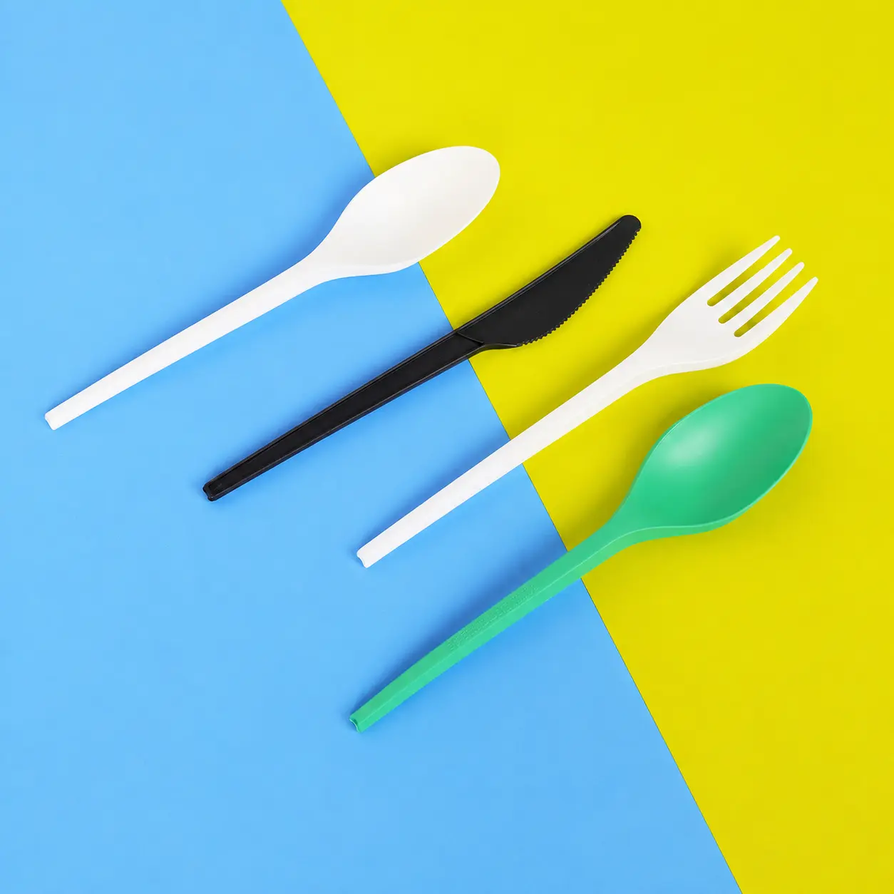 6-5-inch-cpla-cutlery-set-fork-knife-spoon 6.5 inch CPLA biodegradable disposable cutlery set including white fork knife and spoon on blue and yellow background